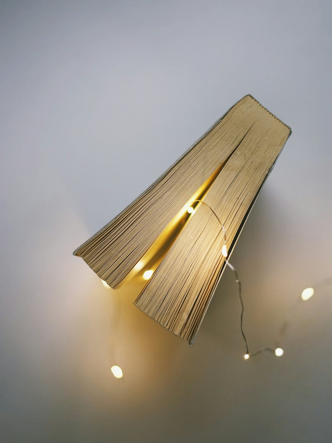 Leuchtende Lichterketten zwischen den Seiten eines aufgeschlagenen Buches.