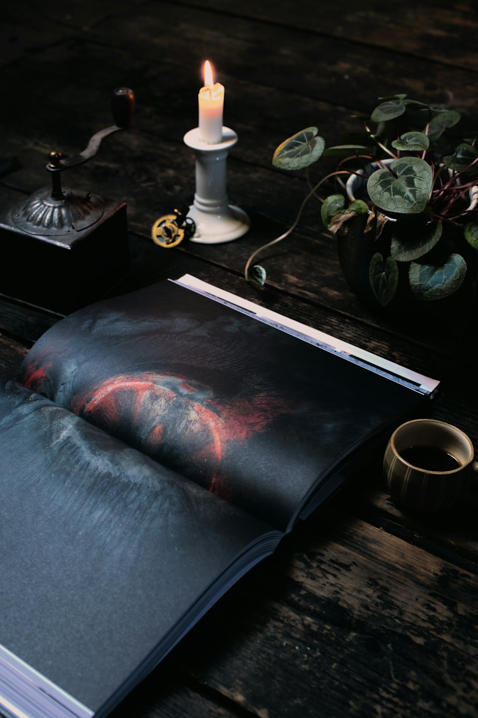 Kunstbuch und Kaffeegedeck auf einem rustikalen Holztisch.