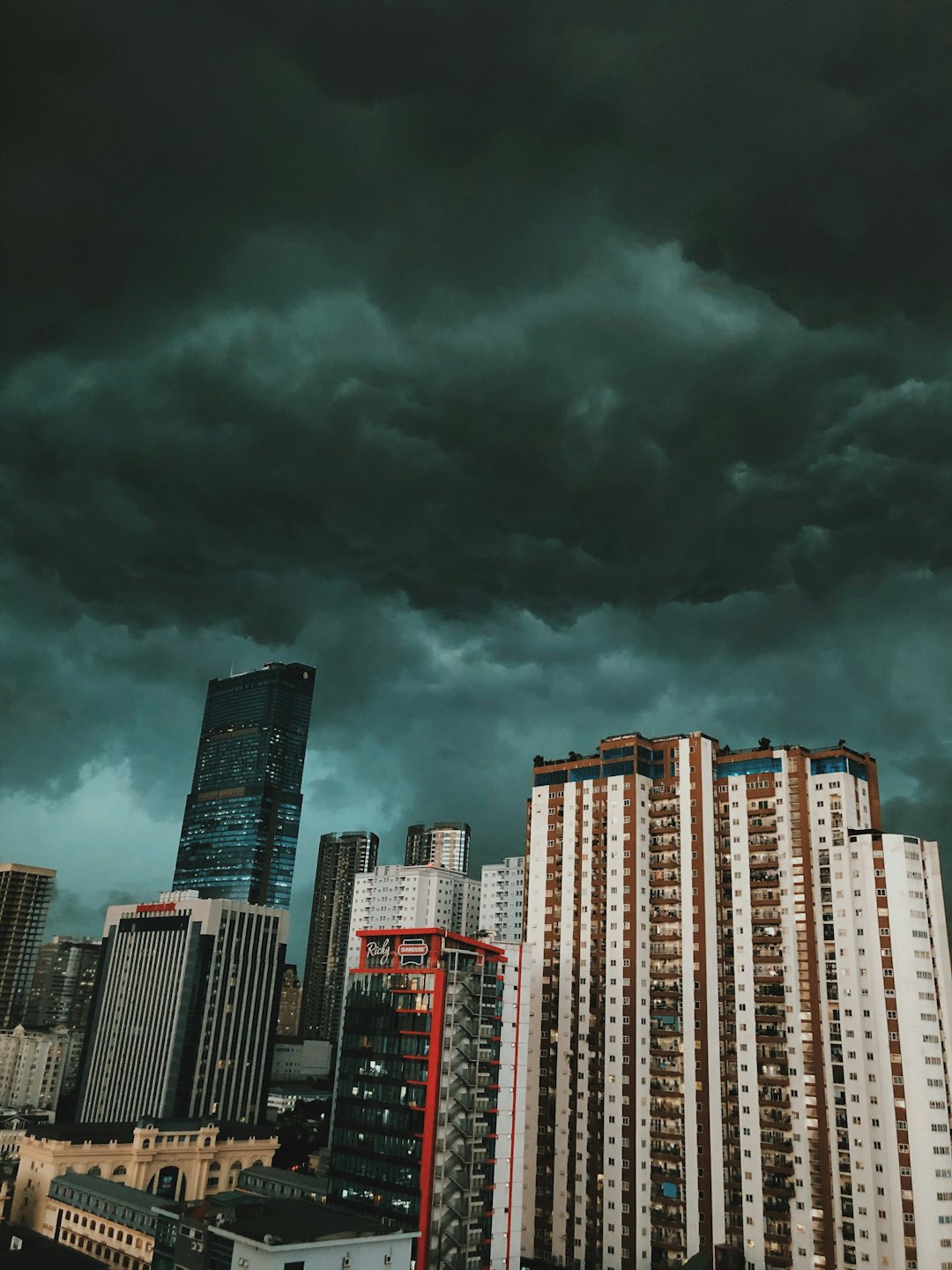 Dunkle Sturmwolken ziehen über eine dichte Stadtkulisse auf.